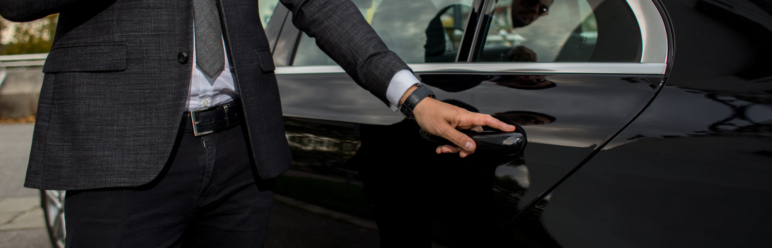 Man opening a black car limousines door